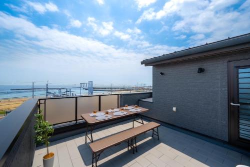 a balcony with a table and a view of the ocean at Town House Suma in Kobe