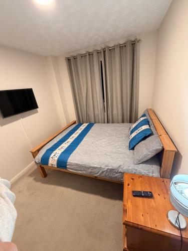 a small bedroom with a bed and a table at Adam Guest House in Leicester