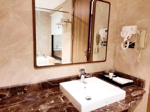 un bagno con un lavandino bianco e uno specchio di Quynh Trang Hung Yen Hotel a HÆ°ng YÃªn