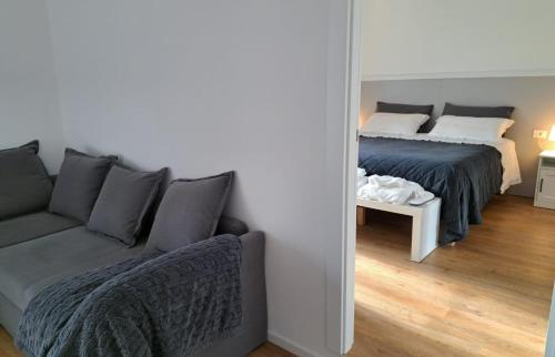 una camera con letto, divano e specchio di Antica Dimora Petito Luxury Suites a Matera