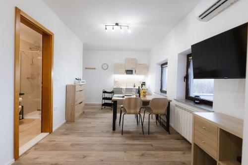 een keuken en eetkamer met een tafel en een televisie bij Apartma Castrum Vini in Ajdovščina