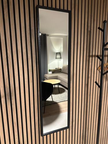 uno specchio che riflette una stanza con divano e tavolo di Layla's Home Free Parking a Sarajevo