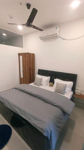 a bedroom with a large bed with a fan at NXone STUDIO APARTMENT in Noida