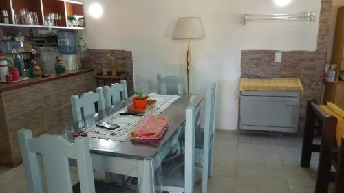 un tavolo da pranzo con sedie in una stanza con cucina di Todos los santos 590 a Miramar