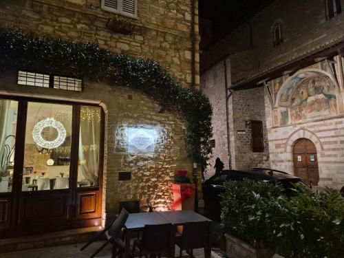 un tavolo e delle sedie davanti a un edificio di Suite Assisi ad Assisi