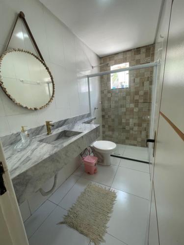 a bathroom with a sink and a toilet and a mirror at Brisa Mar in Canavieiras