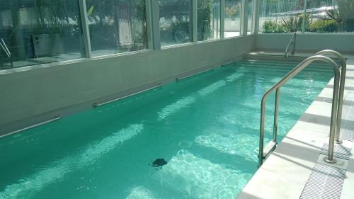 a swimming pool with blue water in a building at Concón Apartment in Concón