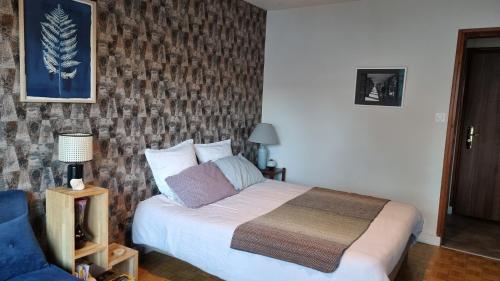 een slaapkamer met een bed en een blauwe stoel bij Studio Roy Gradlon Quimper in Quimper