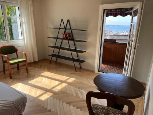 a room with a room with a table and a window at Sunset View Apartment Bregenz Bodensee in Bregenz