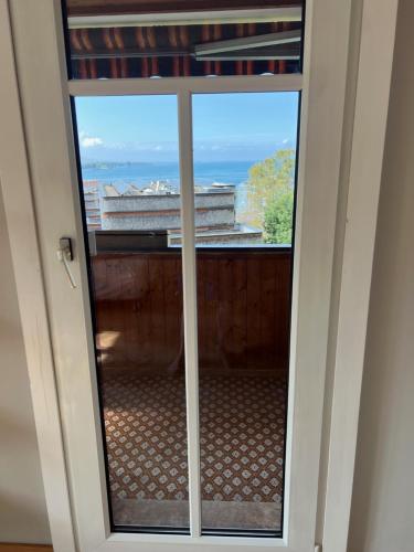 a sliding glass door with a view of the ocean at Sunset View Apartment Bregenz Bodensee in Tannenbach
