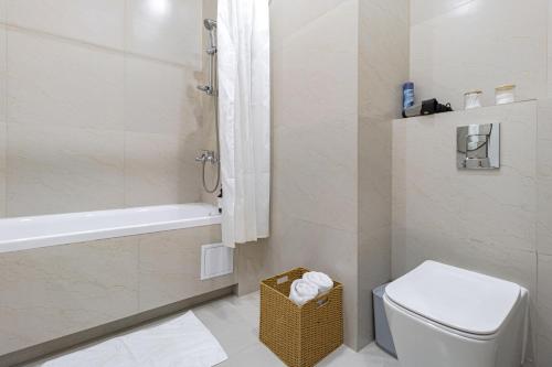 a bathroom with a toilet and a tub and a sink at Мандаринка in Taldykolʼ