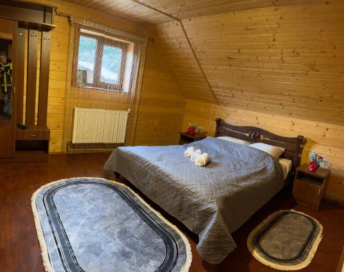 ein Schlafzimmer mit einem Bett, auf dem ein Teddybär liegt in der Unterkunft Котедж біля річки in Kelechin