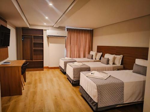 een hotelkamer met drie bedden en een televisie bij Amazon Seasons hotel in Belém