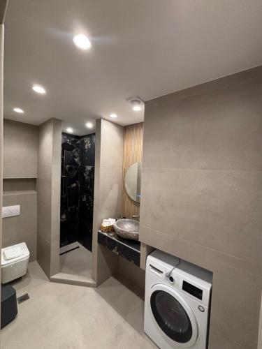 a bathroom with a washing machine and a toilet at The Cozy Residence in Veria