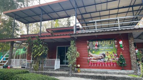 a red house with a christmas sign on it at Mook Phoopha Guest House in Koh Mook