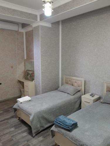 una camera da letto con due letti e un tavolo di Butik a Ganja