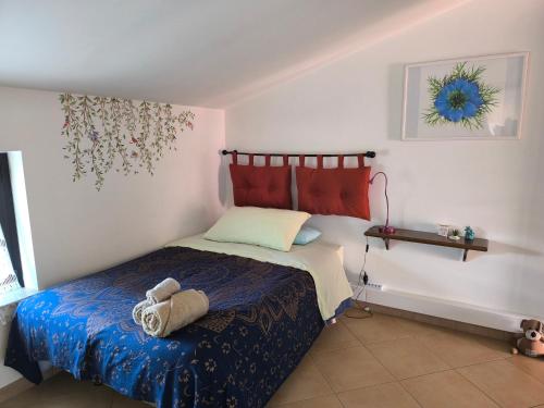 a bedroom with a bed with a blue comforter at Mansarda a 200 mt. dal mare in Roseto degli Abruzzi