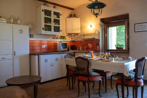 - une cuisine avec une table, des chaises et une table dans l'établissement Cascina Zan, à Paroldo