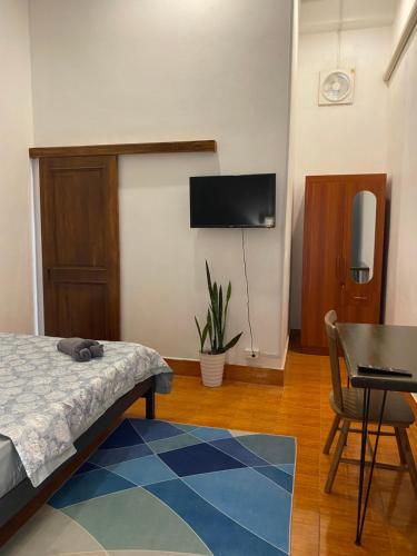 una camera da letto con un letto e una TV a parete di Casa Primera a Luang Prabang