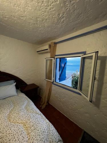 een slaapkamer met een raam met uitzicht op de oceaan bij CHY dreams in Cabo Negro