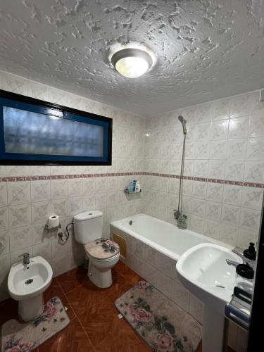 een badkamer met toilet, bad en wastafel bij CHY dreams in Cabo Negro