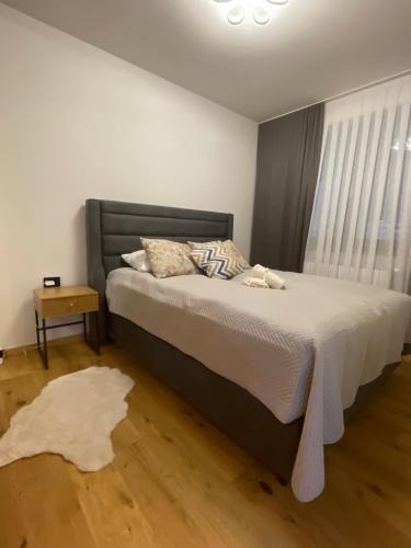 a bedroom with a bed and a window with a rug at Apartman Yellow Bjelasnica in Bjelašnica