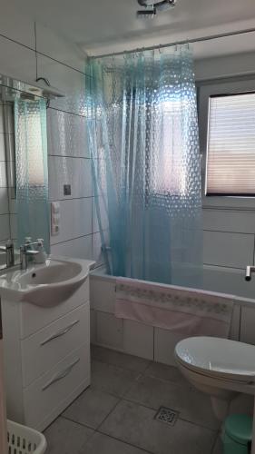 een badkamer met een bad, een wastafel en een toilet bij Apartment Hermeskeil 3 in Hermeskeil