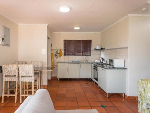 une cuisine avec des armoires blanches et une table et des chaises dans l'établissement 26 on Greenway, à White River