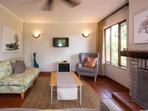 un salon avec un canapé et une chaise dans l'établissement 26 on Greenway, à White River