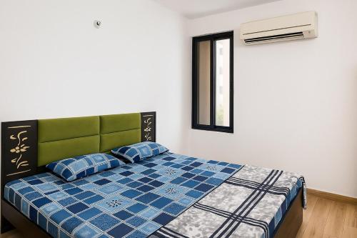 a bedroom with a bed with blue sheets and a window at 2 Bhk Mayra Homes in Raipur