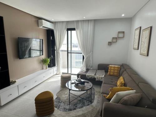 a living room with a couch and a tv at Studio au point E in Dakar