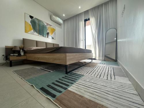 een slaapkamer met een groot bed en een tapijt bij Studio au point E in Dakar