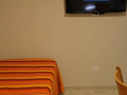 een kamer met een bed en een tv aan de muur bij Edificio-Pellegrini PA in Bragado