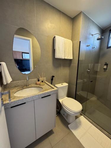 a bathroom with a toilet and a sink and a shower at Nomar Carneiros - Flat Beira-mar in Tamandaré
