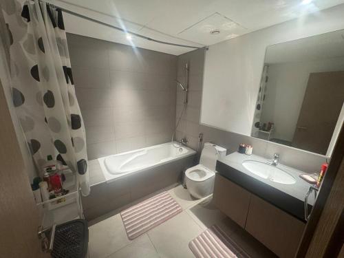 een badkamer met een bad, een toilet en een wastafel bij Full apartment at excellent Community in Sharjah