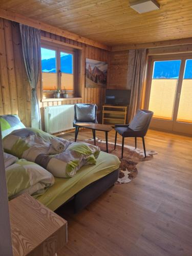 een slaapkamer met 2 bedden en 2 stoelen. bij Winklgut Bacher in Uttendorf