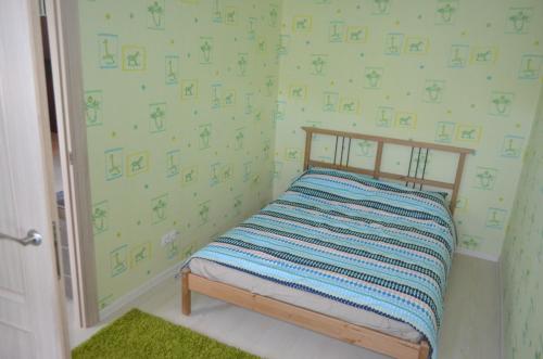 ノヴォシビルスクにあるApartments on Dusi Kovalchuk 266/1の緑の壁紙の小さなベッドルーム1室(ベッド1台付)
