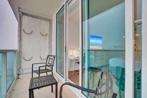 a room with a balcony with a chair and a bed at Bright Studio at The Arya City and Bay Access in Miami
