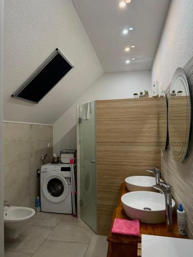 a bathroom with two sinks and a washing machine at KARTAL centar apartment in Bihać