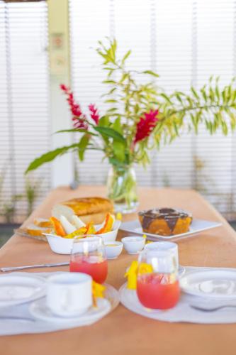 un tavolo con piatti di cibo e un vaso con fiori di AZORAI - Hospedagem Exclusiva a Santa Cruz Cabrália