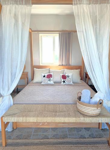 a bedroom with a large bed with white curtains at Zephyr House 3BR Pool, Rooftop & Ocean View in Grande Gaube