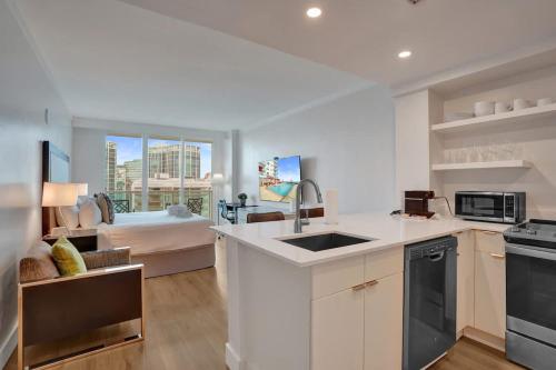 a kitchen with a sink and a living room with a bed at Studio with Bay and City View at The Arya in Miami