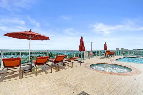 a patio with chairs and an umbrella and a pool at Studio with Bay and City View at The Arya in Miami