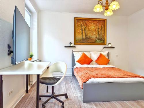 een slaapkamer met een bed en een bureau met een computer bij Zentrales 2-SZ-Apartment Nr 6 - Top-Lage am HBF in Krefeld