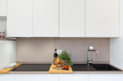 un bancone della cucina con lavandino e una bottiglia di vino di Colosseum Holidays - Marco Aurelio a Roma