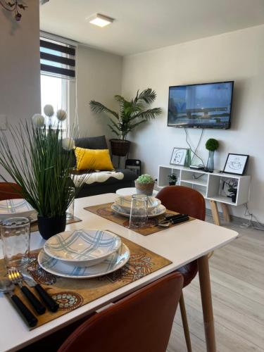 ein Wohnzimmer mit einem Tisch mit Tellern darauf in der Unterkunft Dep al costado del hospital- cercano a safari - buena accesibilidad a carretera panamericana 5 - parking privado in Rancagua