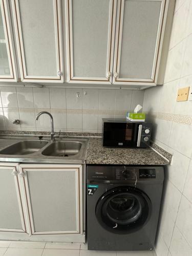 une cuisine avec une machine à laver et un évier dans l'établissement Private double Delight Couple Room, à Abu Dhabi