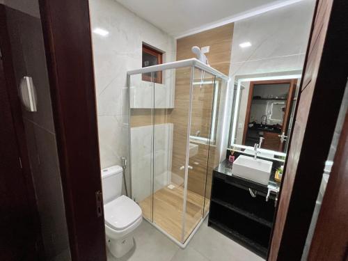 a bathroom with a toilet and a glass shower at Toca do Lobo in Pipa