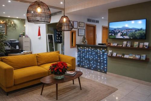 een woonkamer met een gele bank en een tv bij Hotel Mirablau in Aguadulce