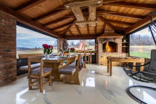 une salle à manger avec une cheminée, une table et des chaises dans l'établissement Family Oasis, Plaški, à Plaški